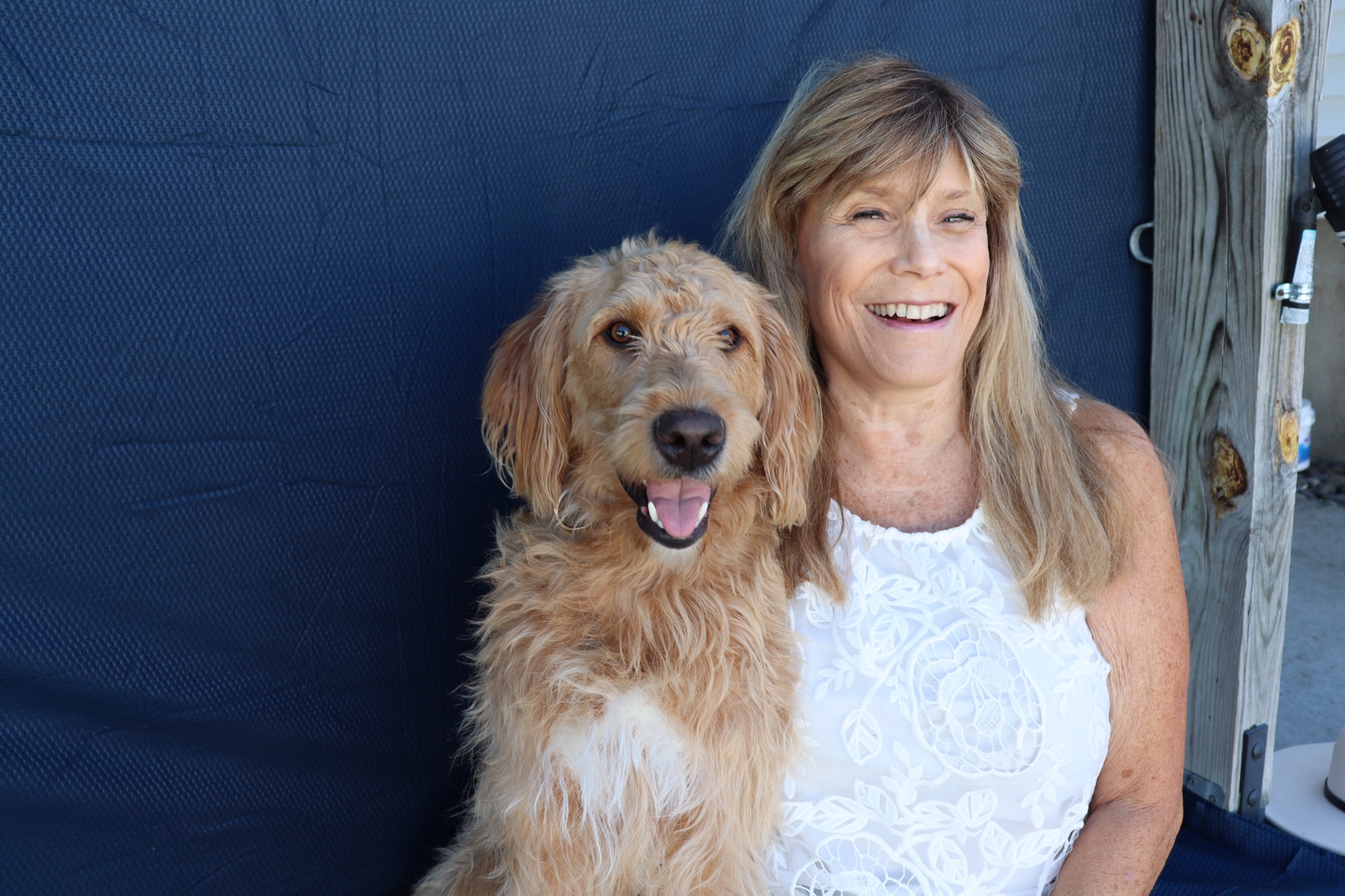 Cheryl McNeil Fisher smiling with her dog Scout looking at the camera